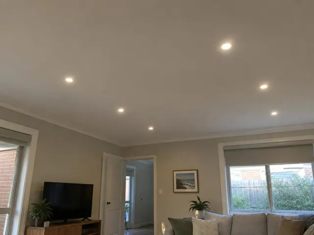 Living room ceiling with recessed downlights above a sofa and TV in a modern home in Cooks Hill